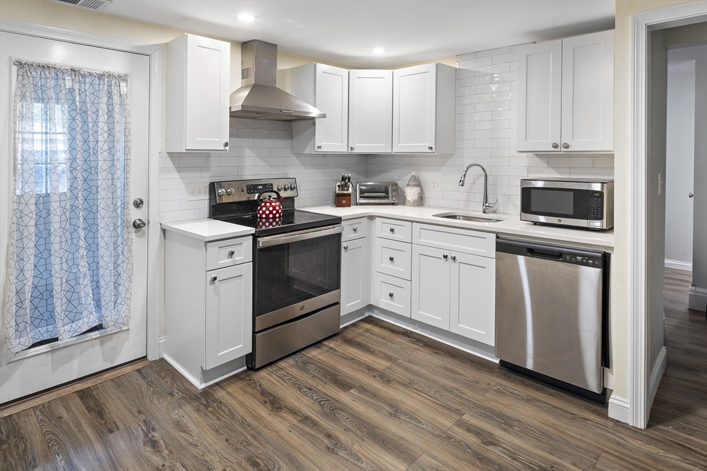 3 Clinton Road Revere, MA 02151 - Photo 10 of 19 a kitchen with cabinets stainless steel appliances and wooden floor
