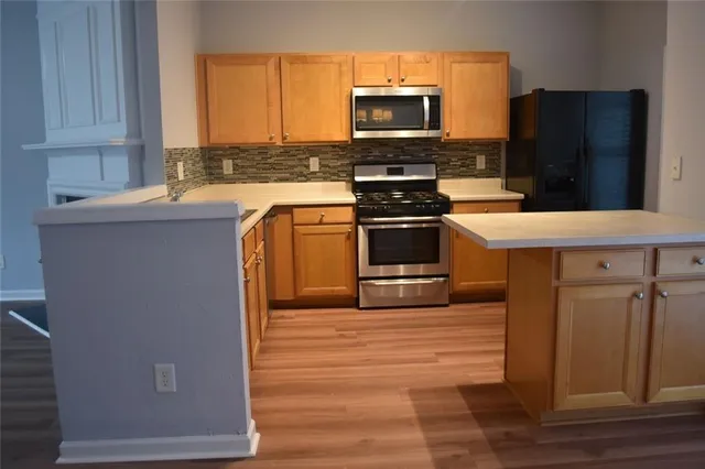 a kitchen with stainless steel appliances a stove microwave and sink