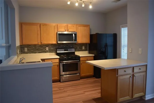 a kitchen with stainless steel appliances a stove microwave and refrigerator