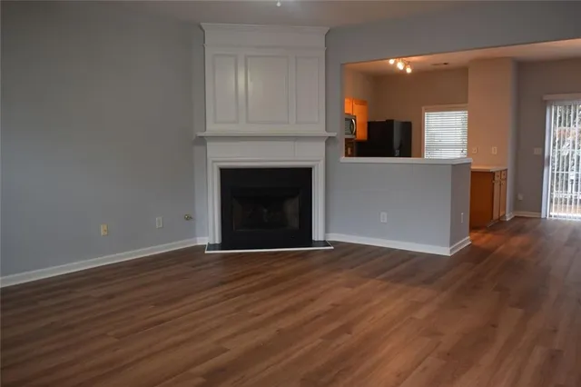 an empty room with wooden floor and fireplace
