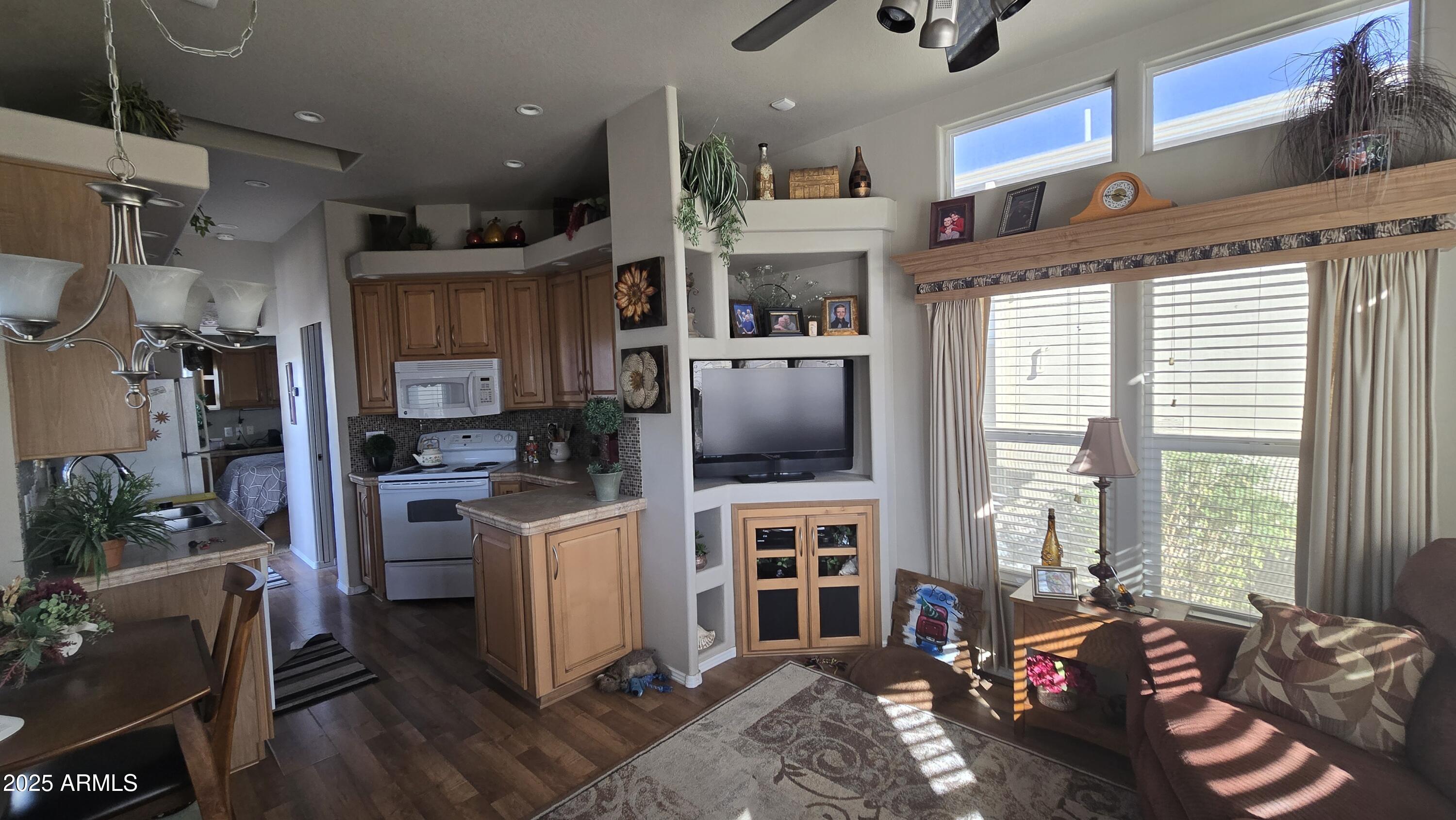 17200 West Bell Road, Unit 1519 Surprise, AZ 85374 - Photo 8 of 21 a living room with furniture a flat screen tv and a floor to ceiling window