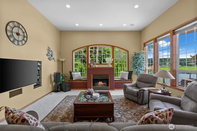 a living room with furniture a fireplace and a floor to ceiling window
