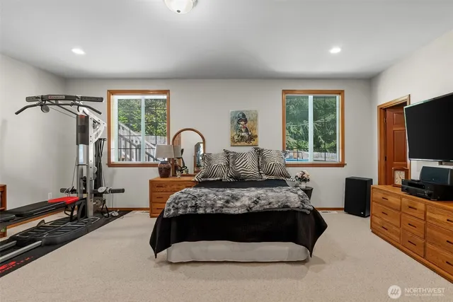 a bedroom with a bed and a flat tv screen on the dresser
