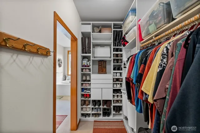 a view of walk in closet with clothes and shoes