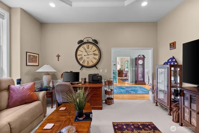 a living room with furniture a clock and a flat screen tv