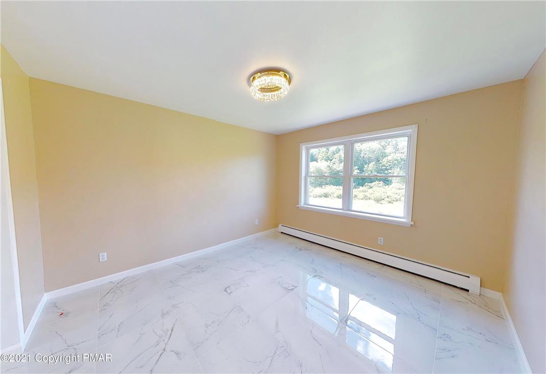 1110 Misty Ridge East Stroudsburg, PA 18302 - Photo 22 of 43 A well-lit room featuring elegant tile flooring and a bright window overlooking natural scenery.