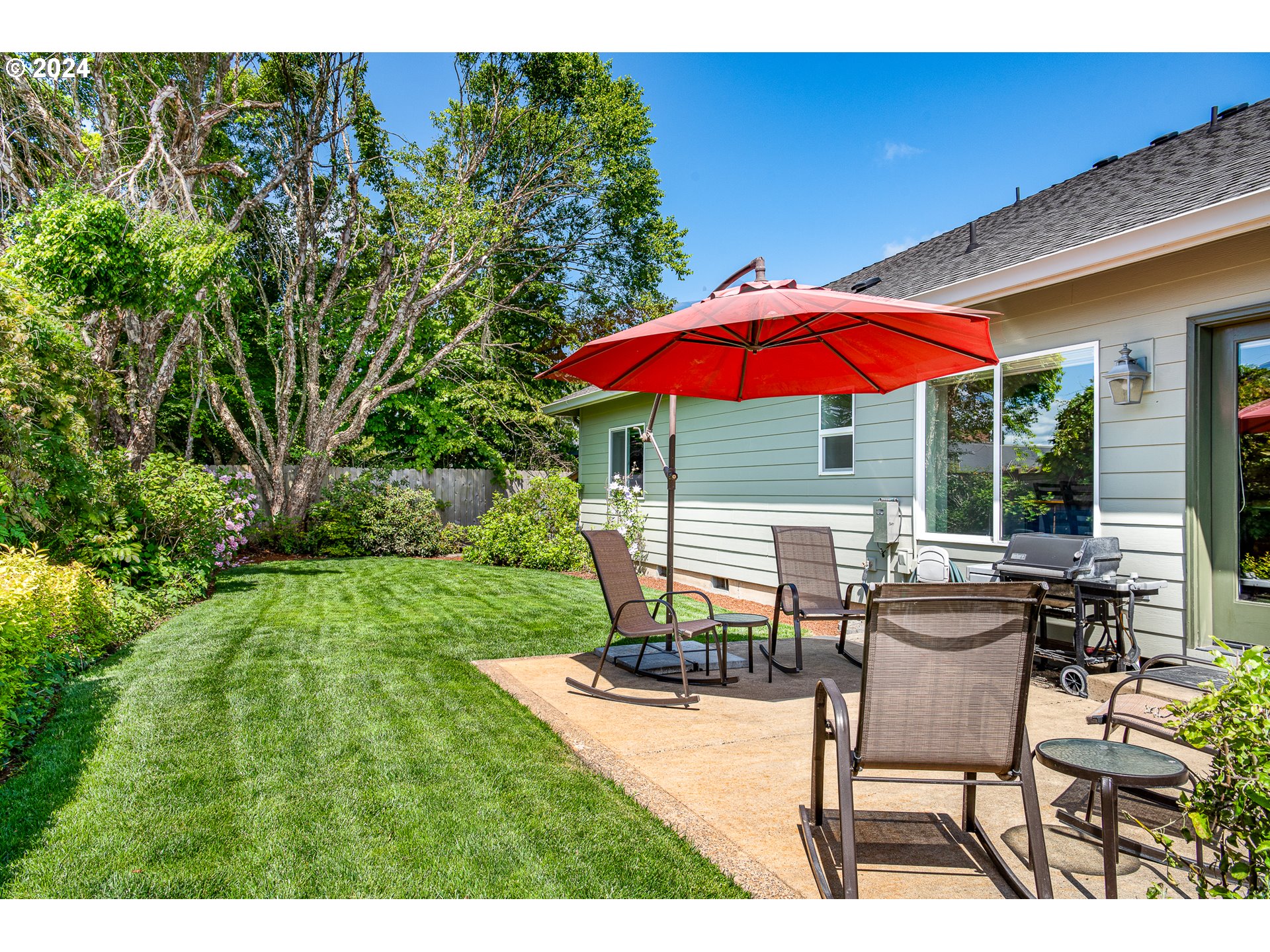 701 Blackstone Street Springfield, OR 97477 - Photo 36 of 40 a view of a patio with chairs and table under an umbrella