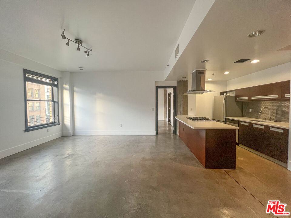 810 South Spring Street, Unit 801 Los Angeles, CA 90014 - Photo 7 of 21 a large room with a large window and kitchen view