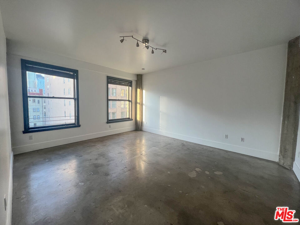 810 South Spring Street, Unit 801 Los Angeles, CA 90014 - Photo 9 of 21 an empty room with windows and ceiling fan