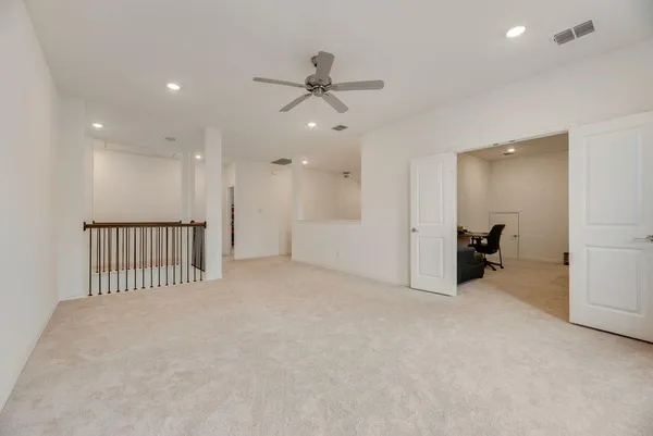 a view of an empty room and a ceiling fan