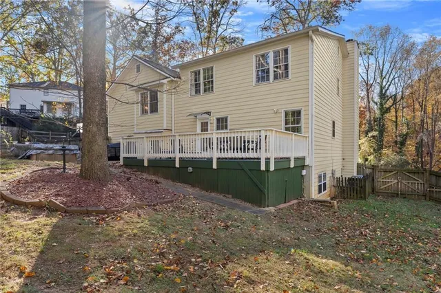 a view of a house with a yard and a large tree