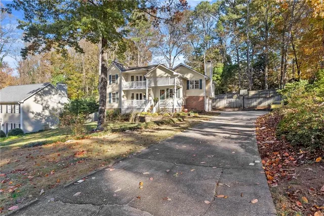 a front view of a house with a yard and trees