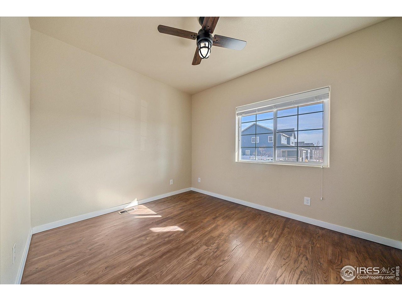 2321 Nicholson Street Berthoud, CO 80513 - Photo 13 of 22 an empty room with wooden floor and ceiling fan