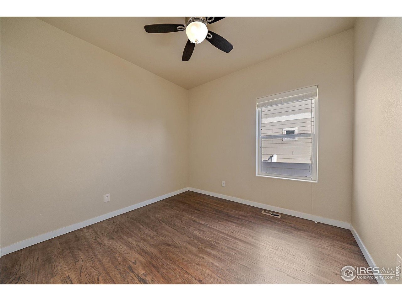 2321 Nicholson Street Berthoud, CO 80513 - Photo 15 of 22 an empty room with wooden floor ceiling fan and windows