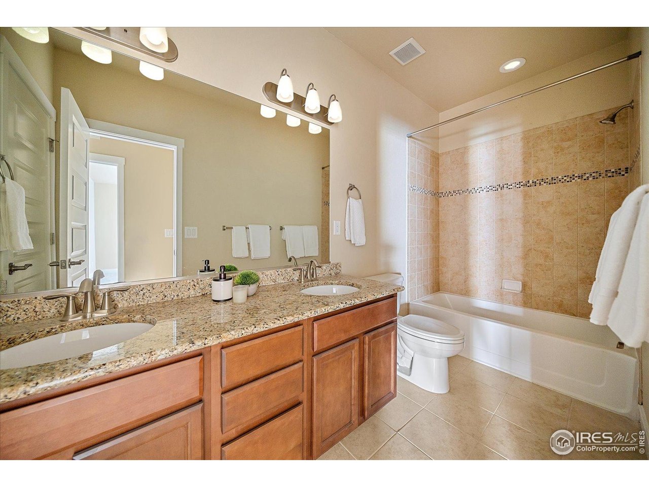 2321 Nicholson Street Berthoud, CO 80513 - Photo 19 of 22 a bathroom with a granite countertop sink a mirror and a shower