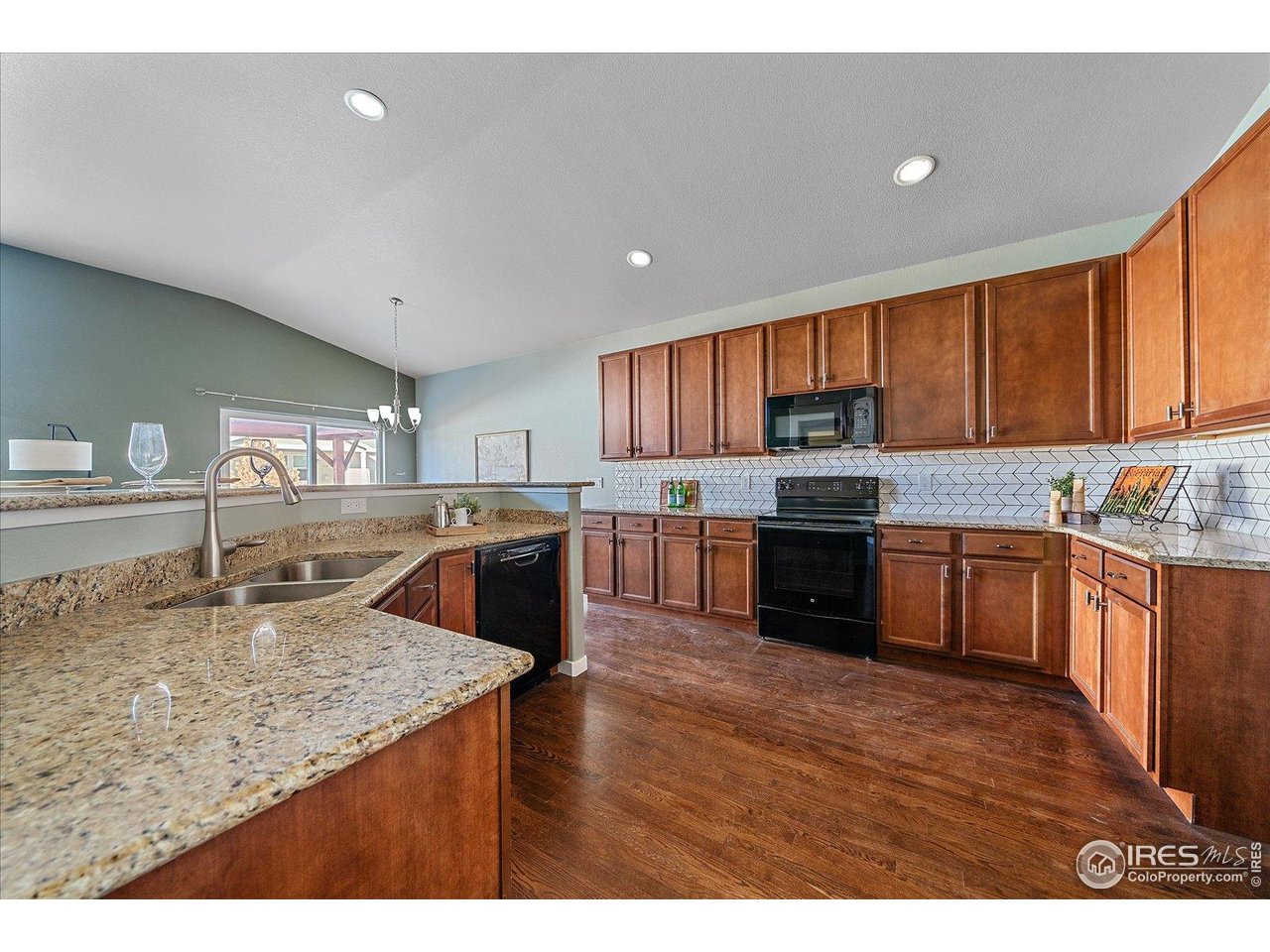 2321 Nicholson Street Berthoud, CO 80513 - Photo 9 of 22 a kitchen with a stove a sink a microwave a center island and a window