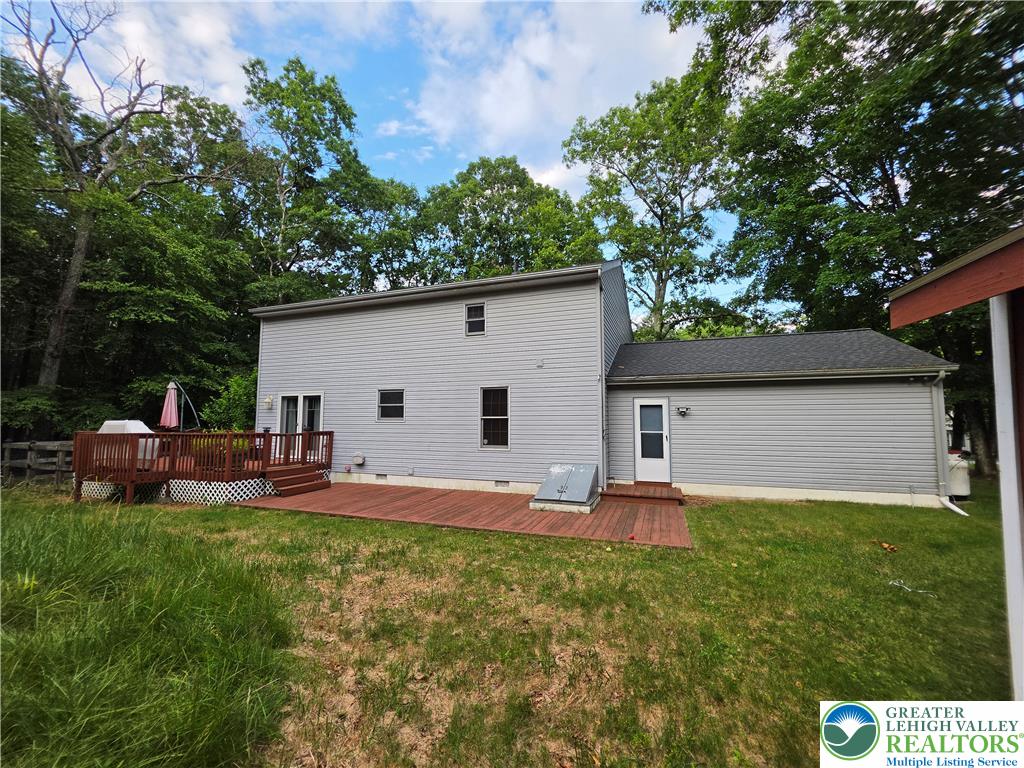 211 Murphy Circle Bushkill, PA 18324 - Photo 21 of 28 Rear facade with an expansive wooden deck, perfect for entertaining amidst a serene treed backdrop.