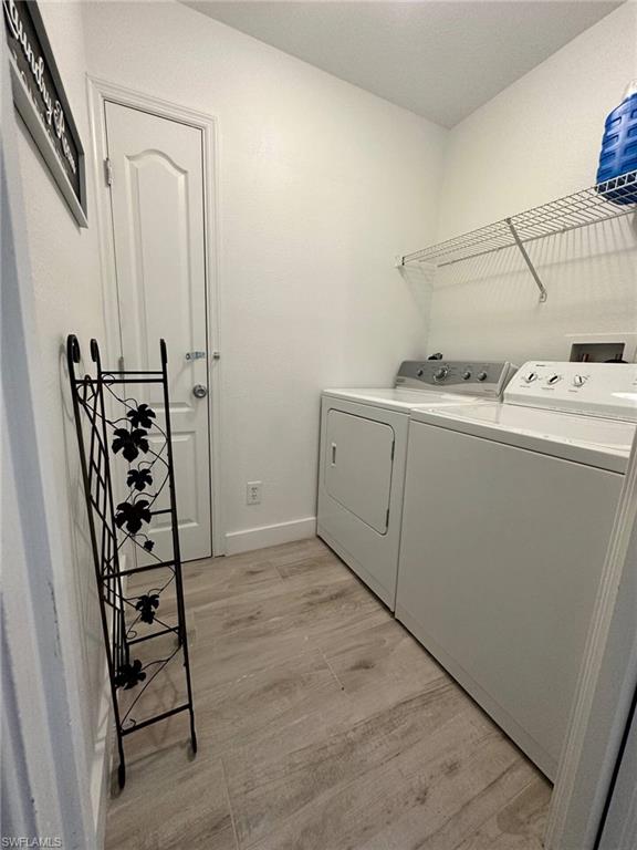 3440 15th Avenue Southwest Naples, FL 34117 - Photo 27 of 31 Laundry area featuring washing machine and clothes dryer and light hardwood / wood-style floors