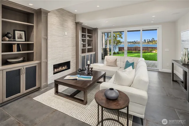 a living room with furniture a fireplace and a floor to ceiling window