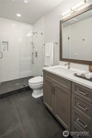a spacious bathroom with a double vanity sink toilet and a mirror