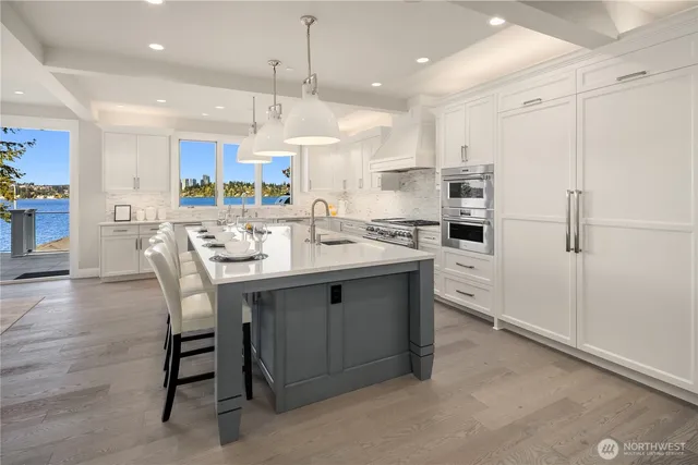 a kitchen with kitchen island granite countertop a table chairs refrigerator and microwave