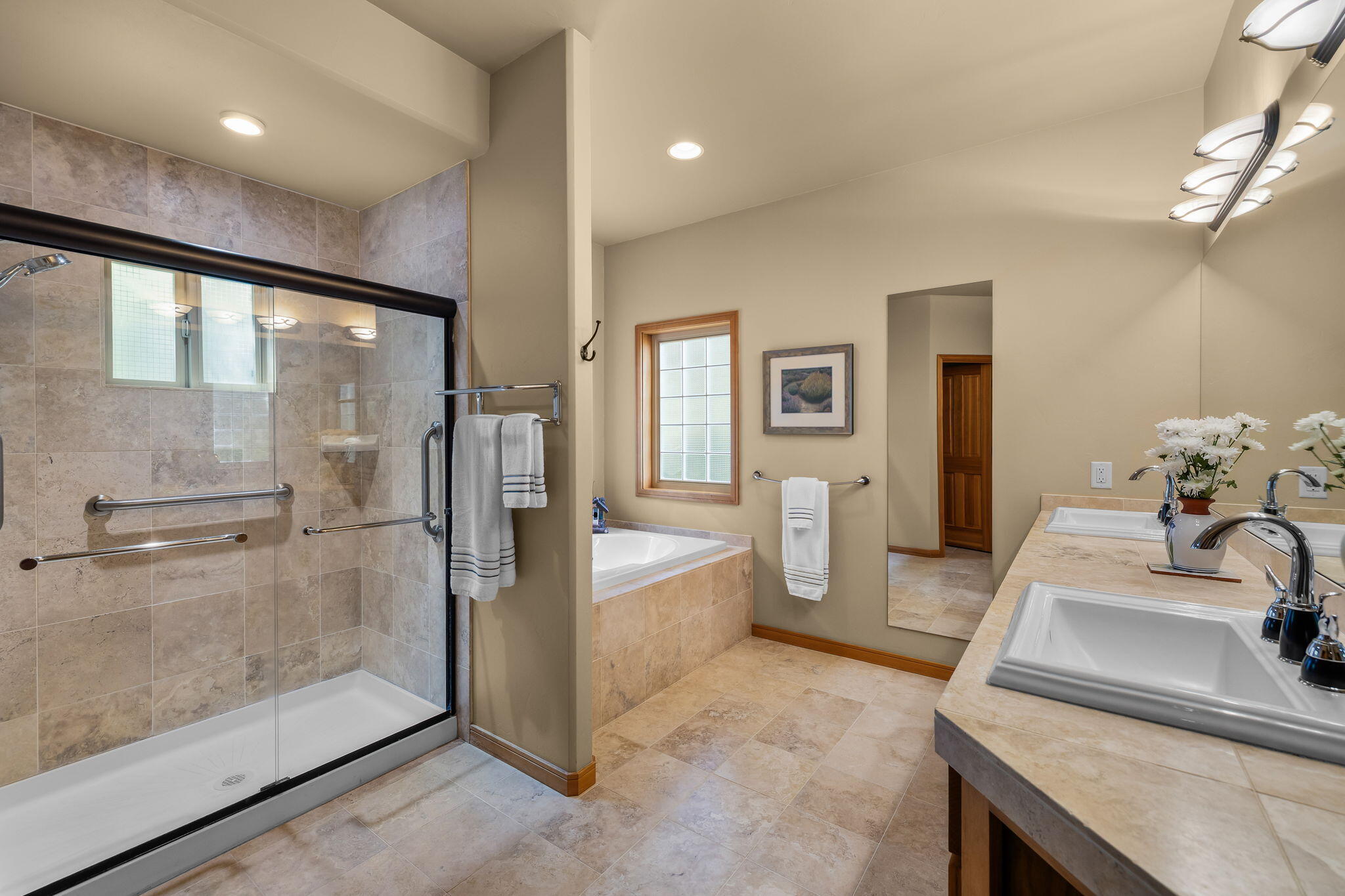 19574 Green Lakes Loop Bend, OR 97702 - Photo 21 of 41 Dual vanities, a large mirror, soaking tub, and separate tiled shower create a comfortable and well-maintained primary bath.