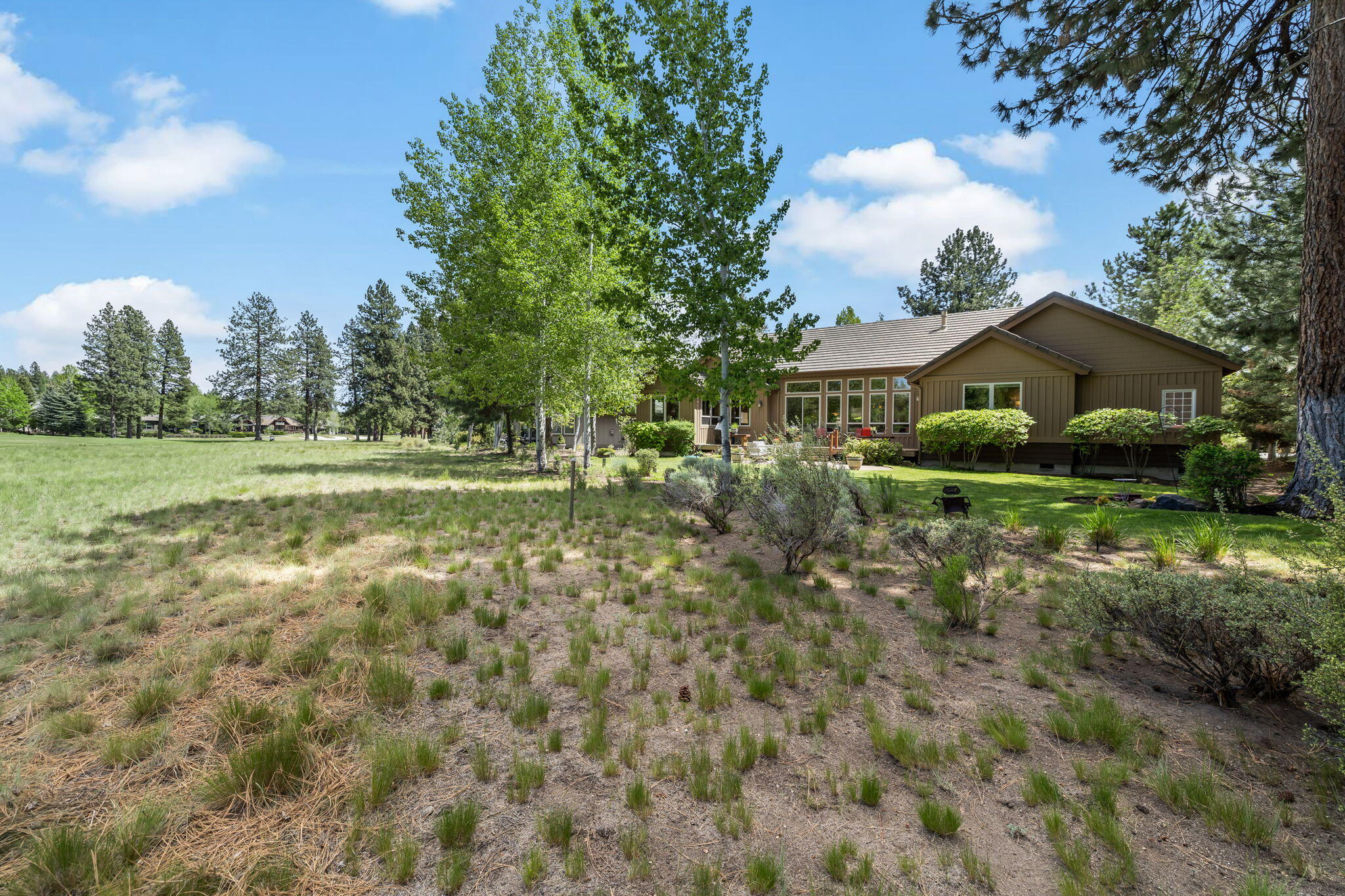 19574 Green Lakes Loop Bend, OR 97702 - Photo 34 of 41 Mature aspens, pines, lawn, and natural landscaping create a beautiful Central Oregon backdrop for outdoor living.