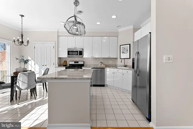 a kitchen with stainless steel appliances granite countertop a stove a refrigerator a oven a sink a dining table and chairs