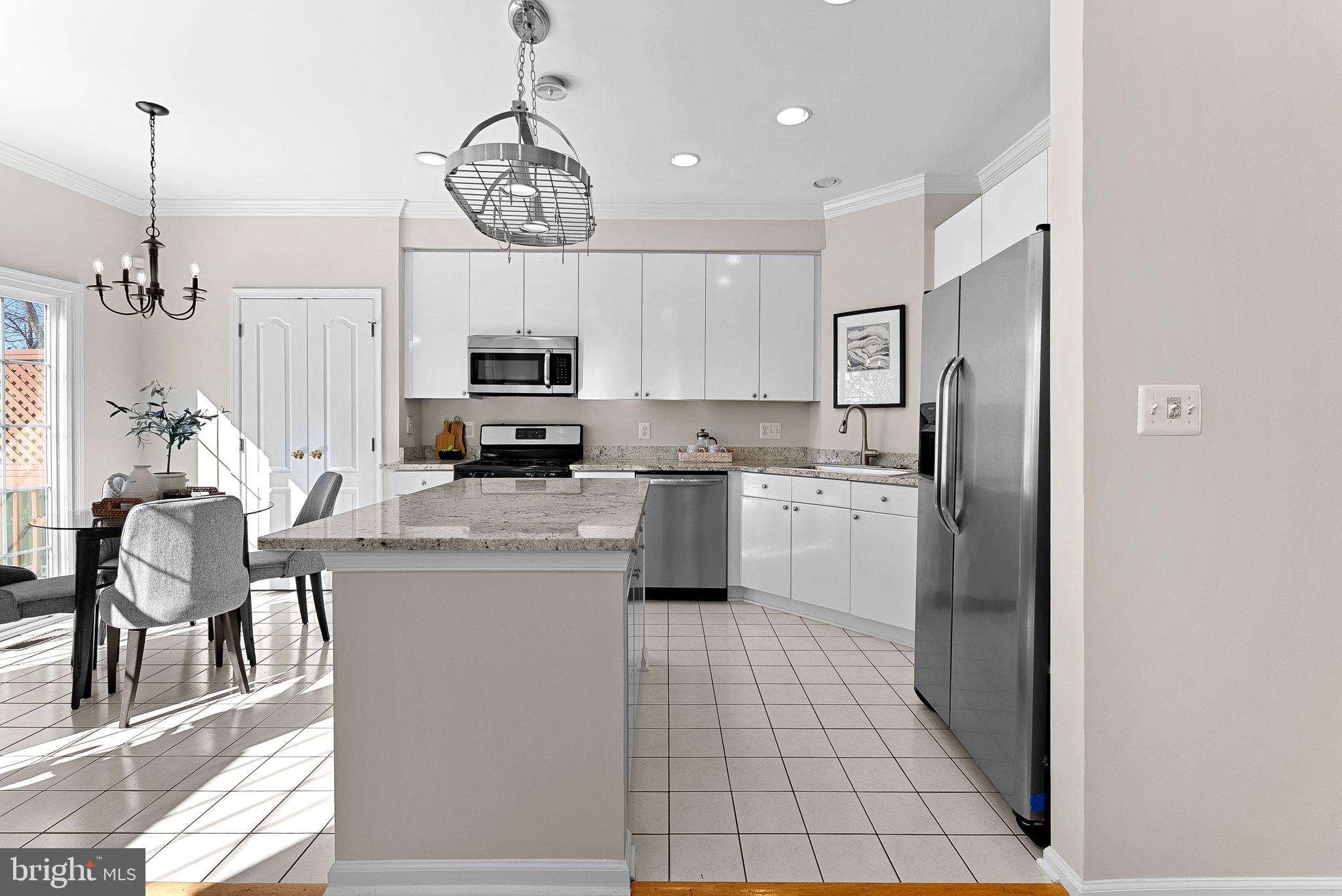 1733 Stuart Pointe Lane Herndon, VA 20194 - Photo 12 of 49 a kitchen with stainless steel appliances granite countertop a stove a refrigerator a oven a sink a dining table and chairs