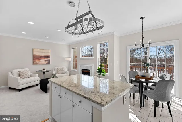 a view of a dining room and livingroom with furniture wooden floor a chandelier