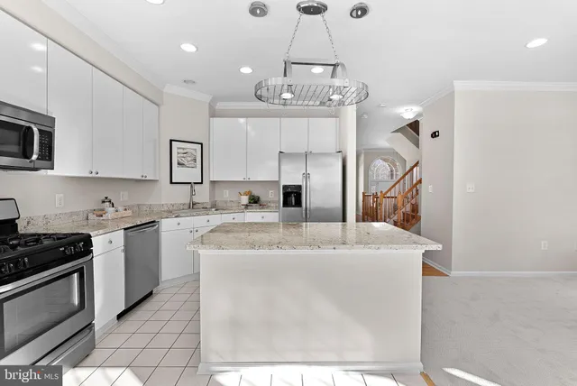 a kitchen with stainless steel appliances granite countertop a sink a stove a refrigerator and cabinets