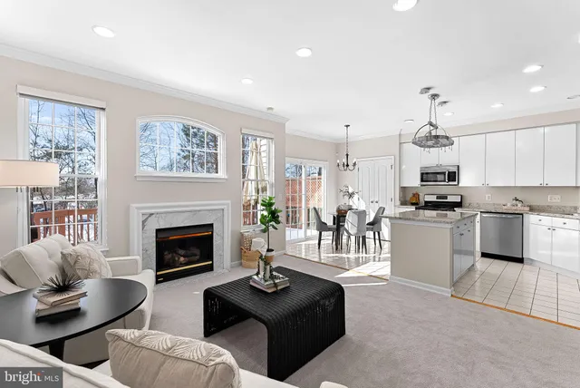 a living room with furniture fireplace and kitchen view