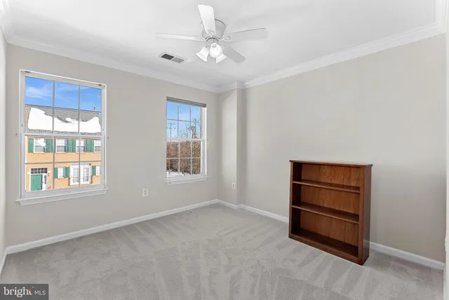 an empty room with closet and fan