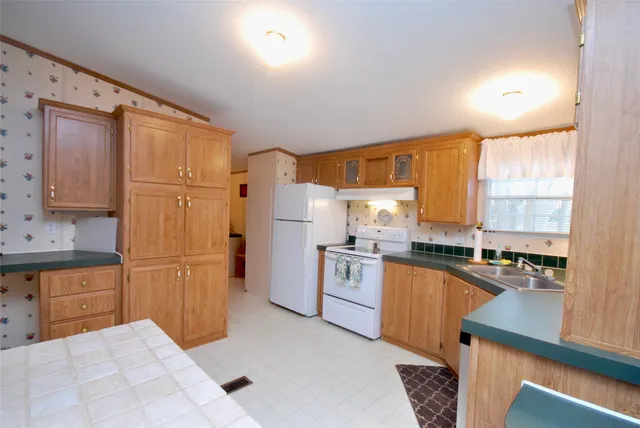 a kitchen with a sink appliances cabinets and a counter top space