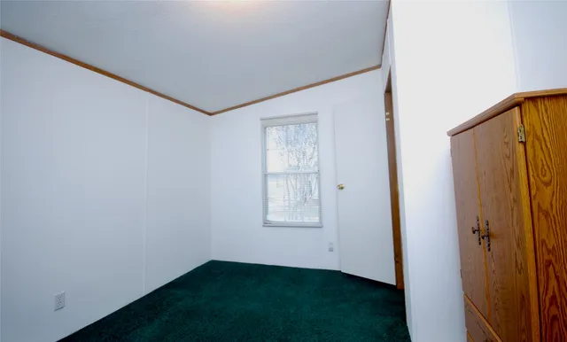 a view of a patio with table and chairs under an umbrella with large trees
