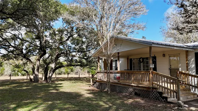 a view of a house with a large window and wooden fence