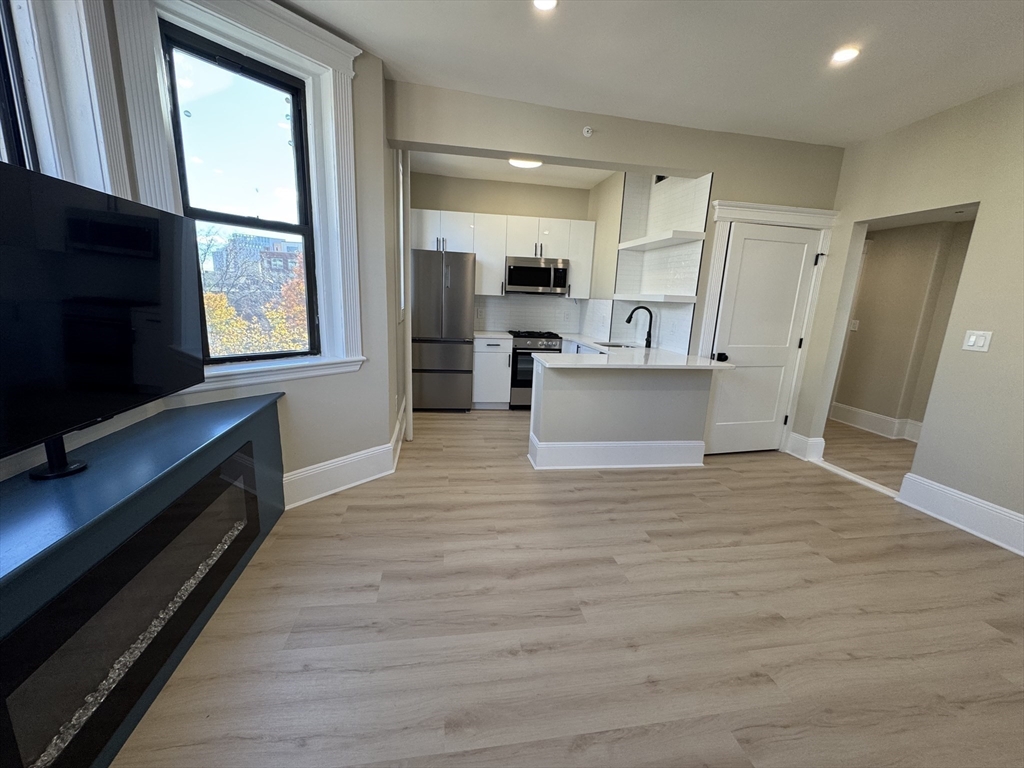 41 Edgerly Road, Unit 32 Boston, MA 02115 - Photo 1 of 13 a view of kitchen with stainless steel appliances kitchen island wooden floor and living room view