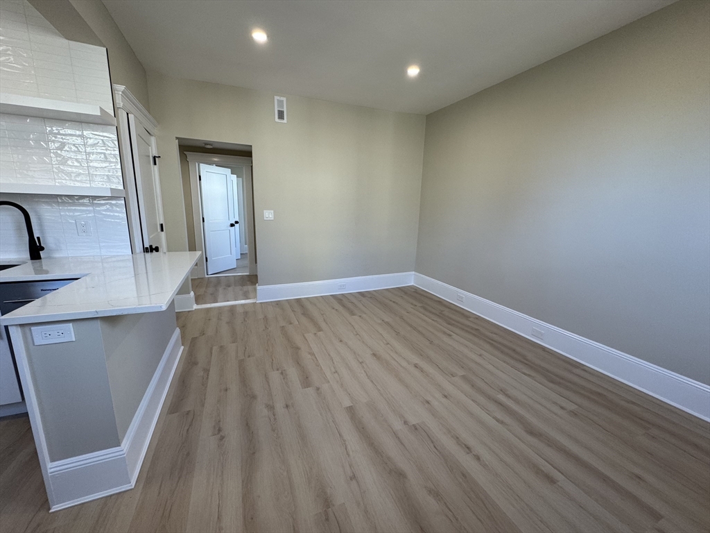 41 Edgerly Road, Unit 32 Boston, MA 02115 - Photo 4 of 13 a view of a kitchen with wooden floor and staircase