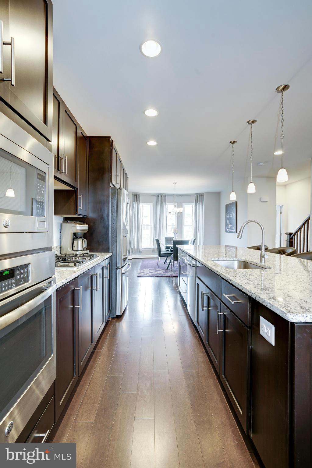 42277 Riggins Ridge Terrace Ashburn, VA 20148 - Photo 12 of 30 a large kitchen with stainless steel appliances lots of counter space and a sink