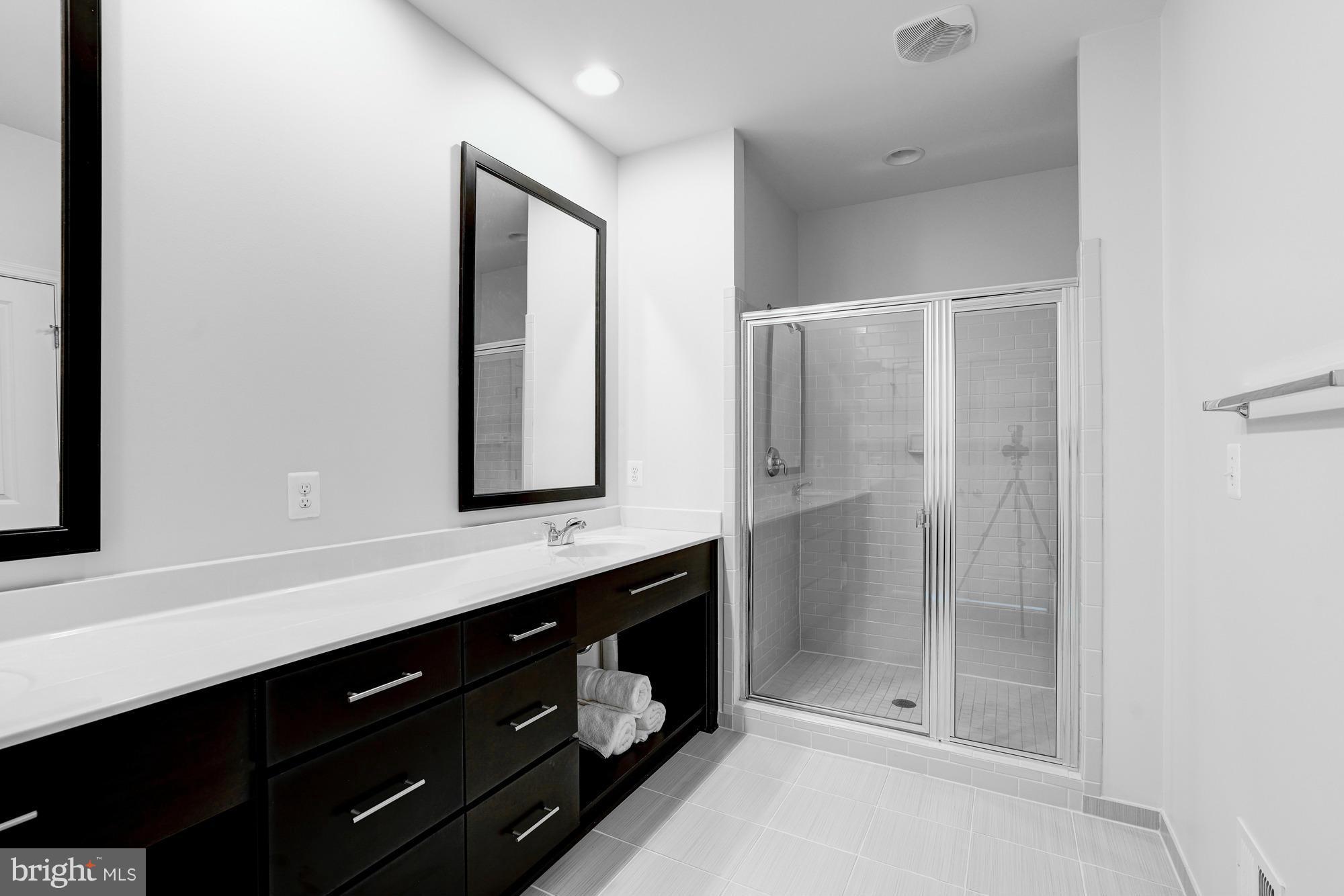 42277 Riggins Ridge Terrace Ashburn, VA 20148 - Photo 19 of 30 a bathroom with a shower sink and mirror