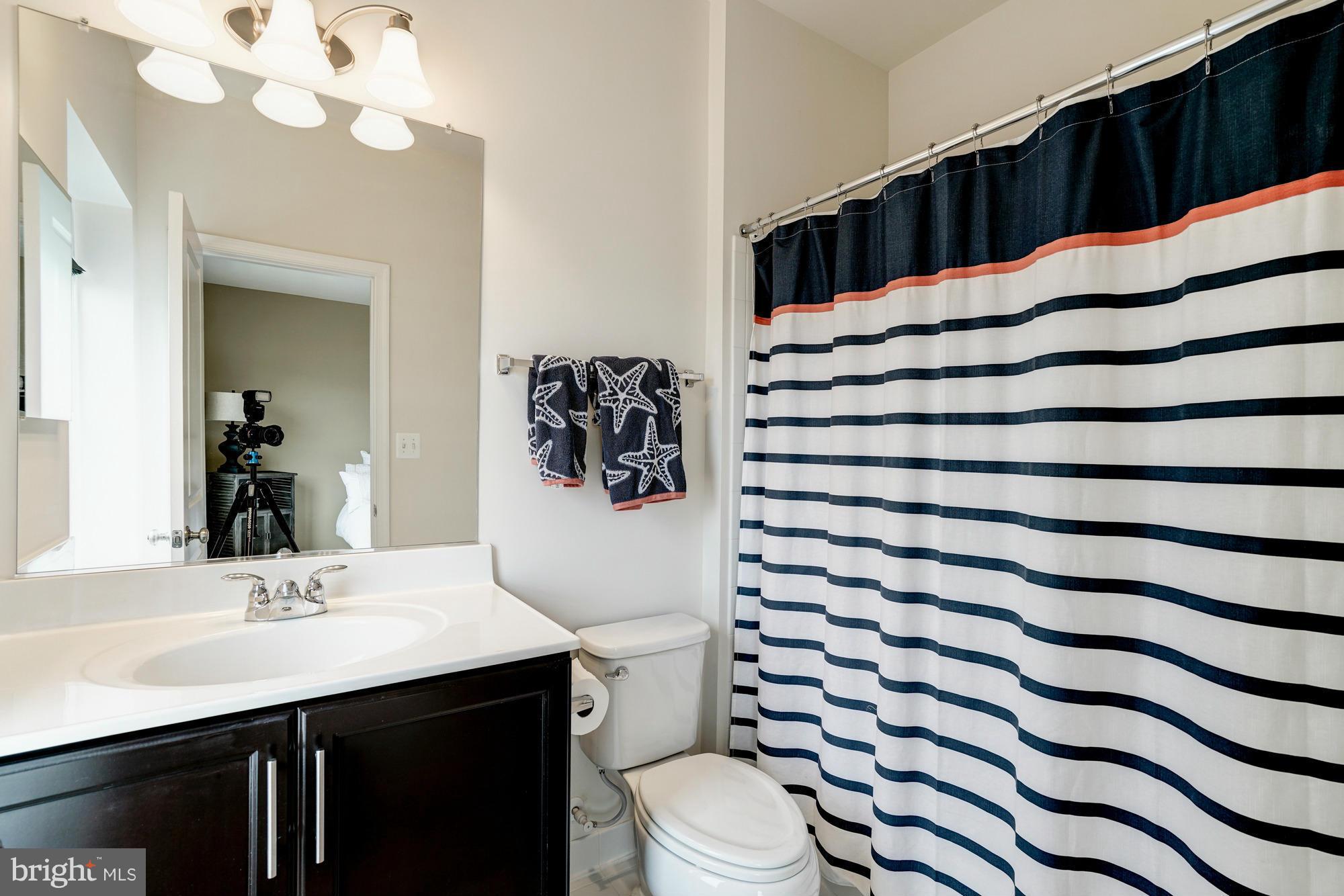 42277 Riggins Ridge Terrace Ashburn, VA 20148 - Photo 23 of 30 a bathroom with a sink vanity mirror and toilet