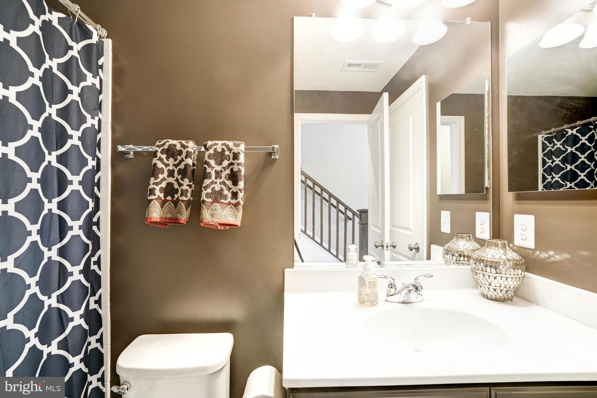 42277 Riggins Ridge Terrace Ashburn, VA 20148 - Photo 27 of 30 a bathroom with a sink mirror vanity and toilet