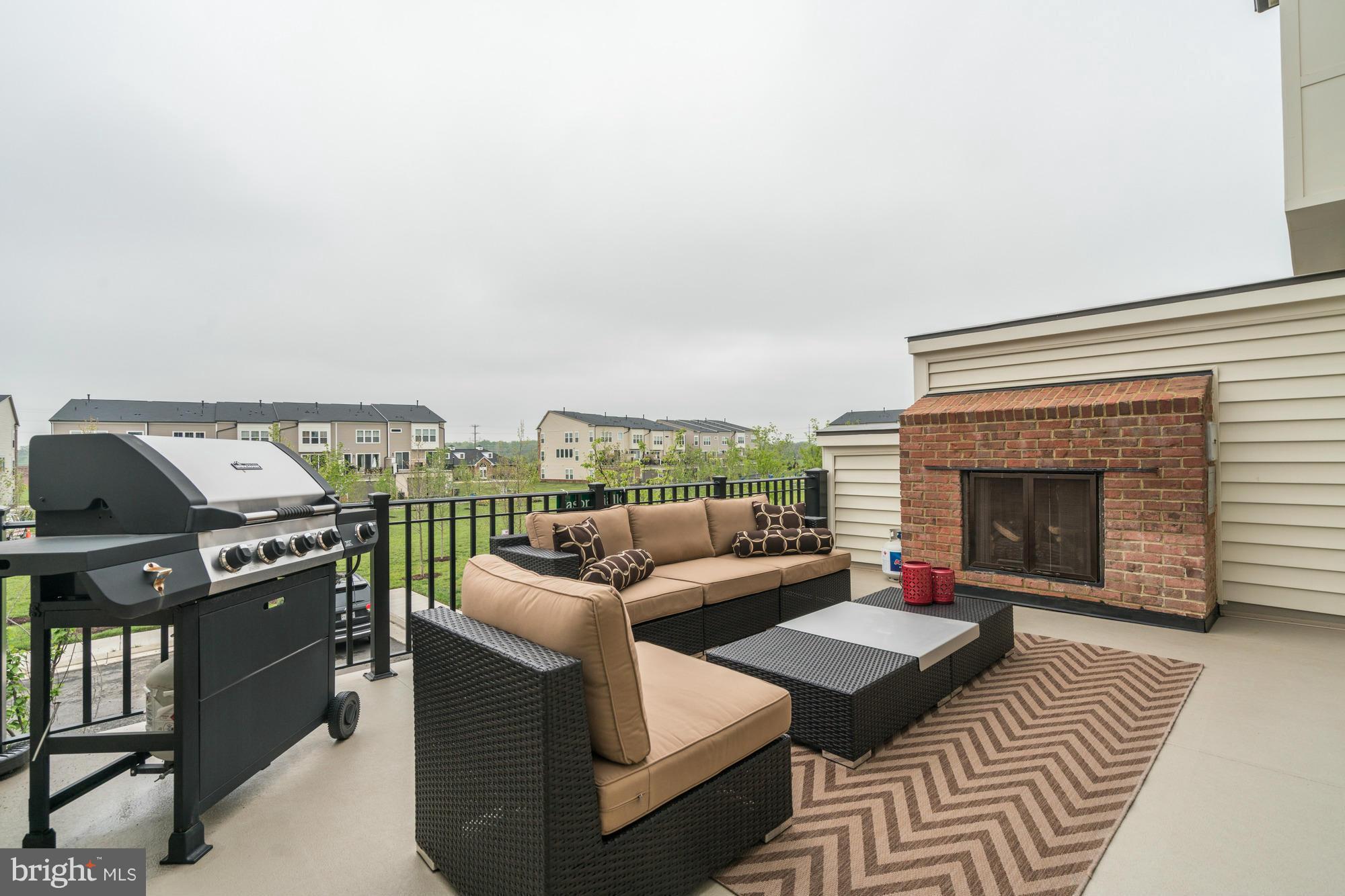 42277 Riggins Ridge Terrace Ashburn, VA 20148 - Photo 28 of 30 a living room with furniture a fireplace and a flat screen tv