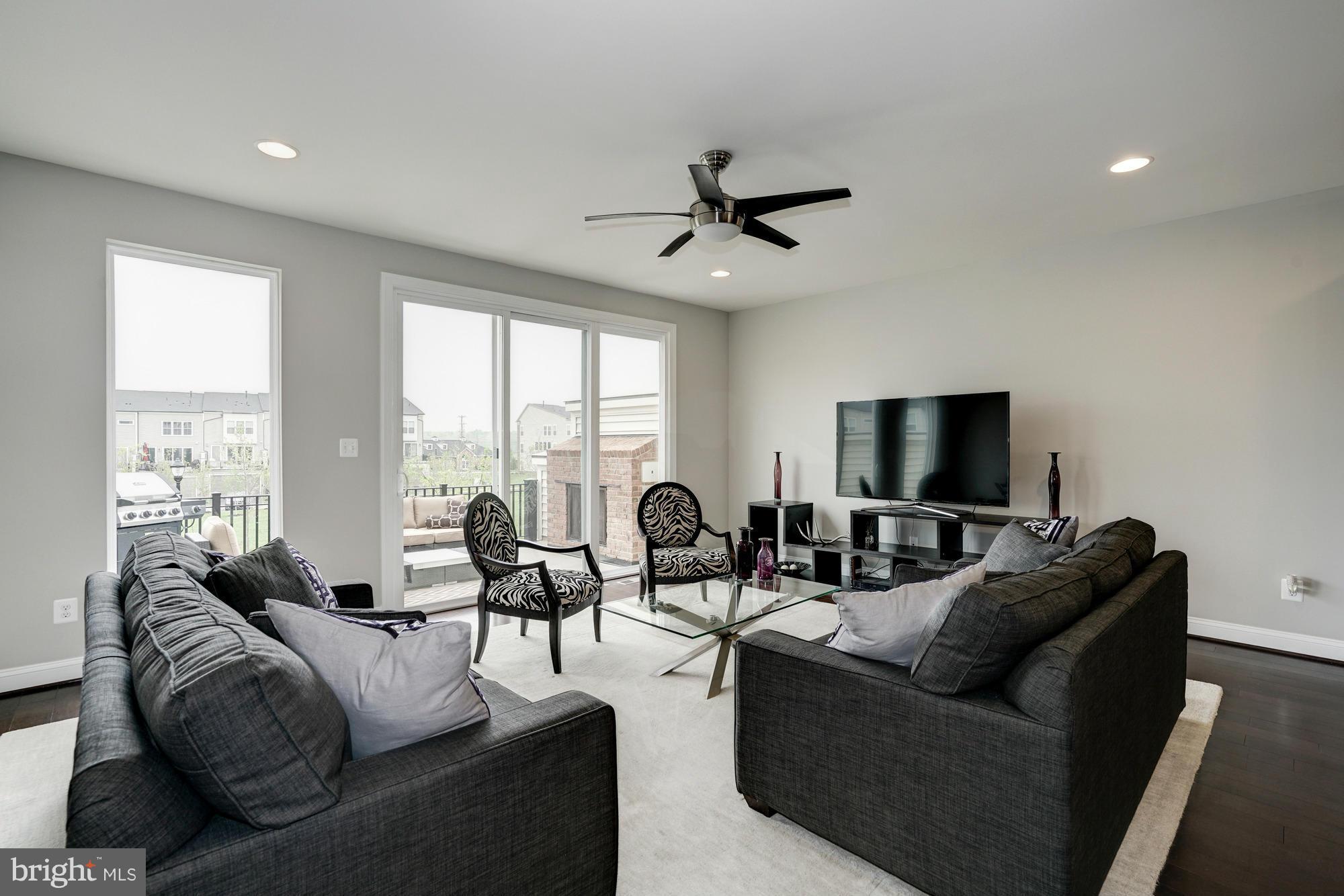 42277 Riggins Ridge Terrace Ashburn, VA 20148 - Photo 6 of 30 a living room with furniture and a flat screen tv