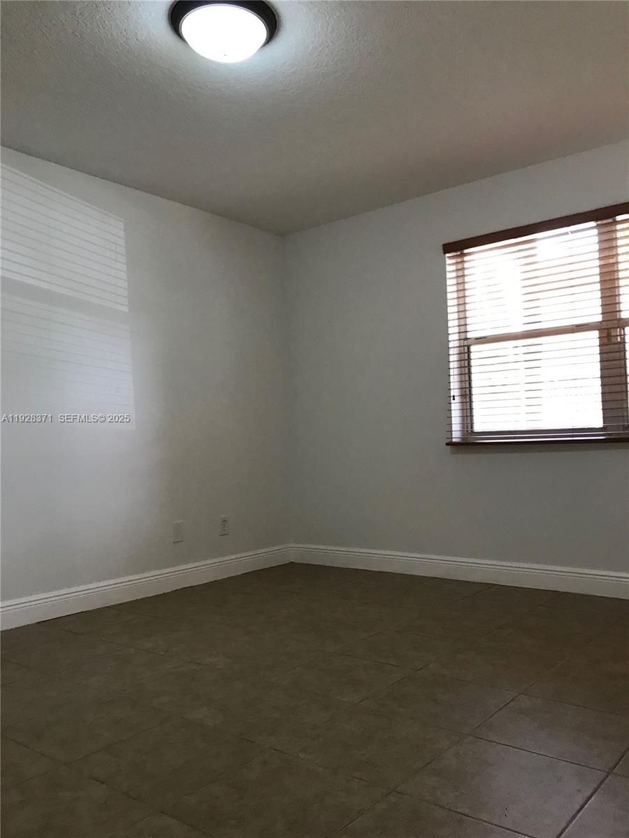 1250 Southwest 113th Terrace, Unit 101 Pembroke Pines, FL 33025 - Photo 12 of 17 an empty room with a window