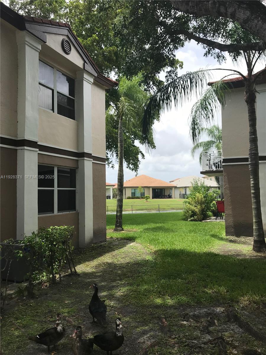 1250 Southwest 113th Terrace, Unit 101 Pembroke Pines, FL 33025 - Photo 15 of 17 a front view of a house with garden