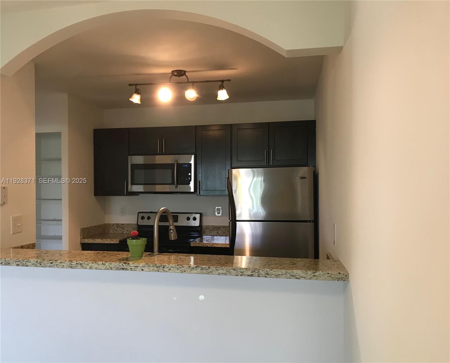 1250 Southwest 113th Terrace, Unit 101 Pembroke Pines, FL 33025 - Photo 6 of 17 a kitchen with a refrigerator and a stove top oven