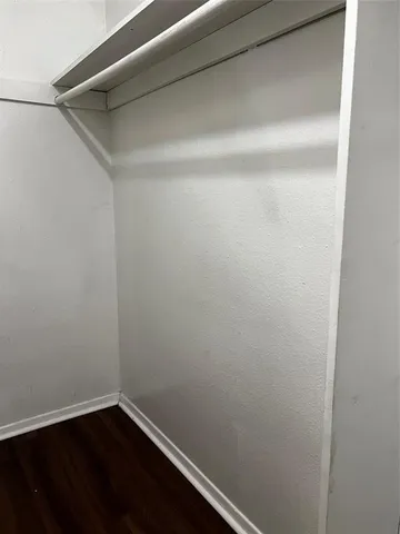 a view of a small space with wooden floor and a window