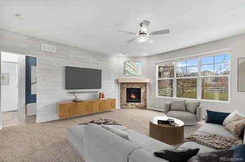 a living room with furniture a fireplace and a flat screen tv