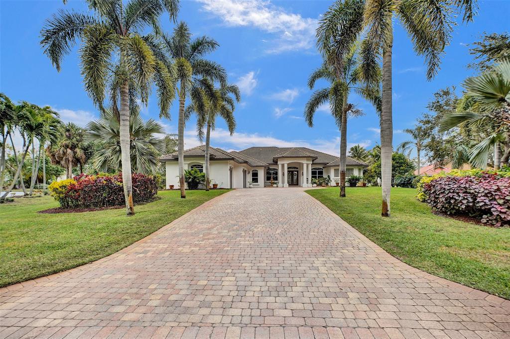 8426 Sawpine Road Delray Beach, FL 33446 - Photo 3 of 91 a front view of a house with a garden and trees